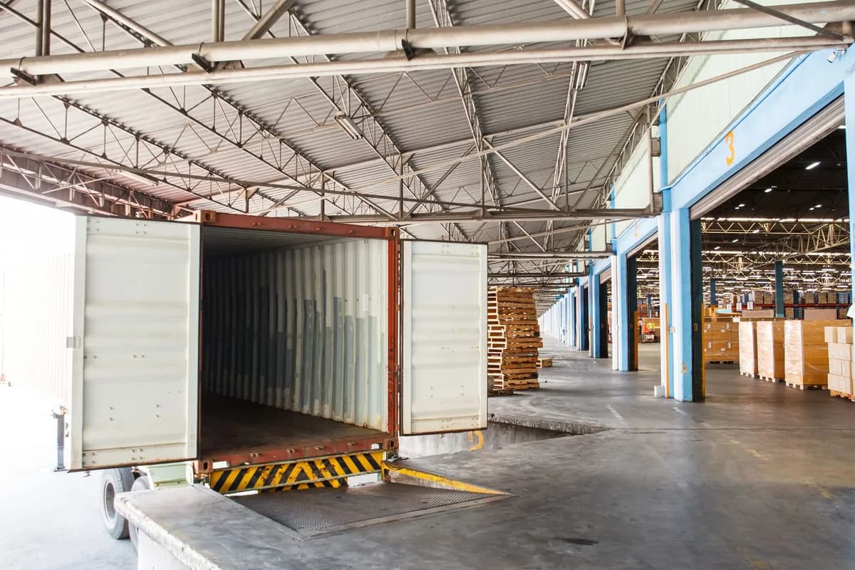 Empty enclosed trailer backed up to a warehouse loading dock