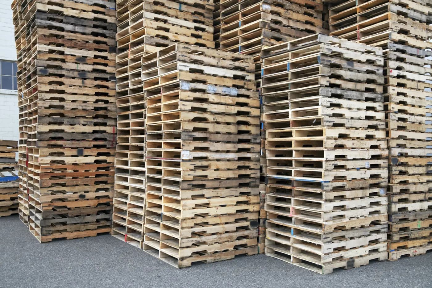 Tall stacks of used wood pallets waiting to be sold